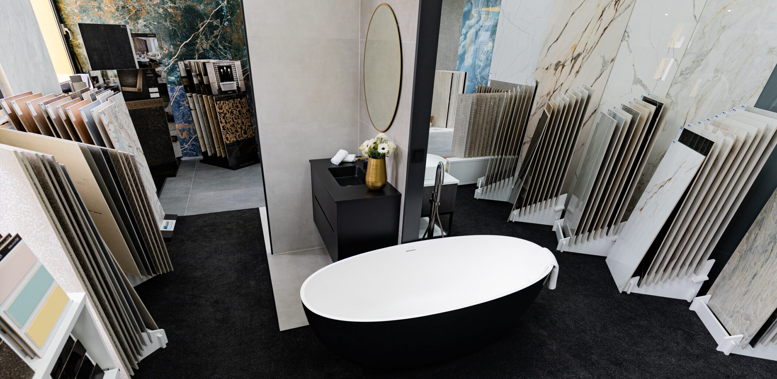 Modernes Badezimmer am Standort Wetzlar mit freistehender Badewanne innen weiß, außen schwarz, freistehender Armatur, Waschbeckenunterschrank und Badmöbeln inklusive Spiegel – ganzheitliche Badplanung.