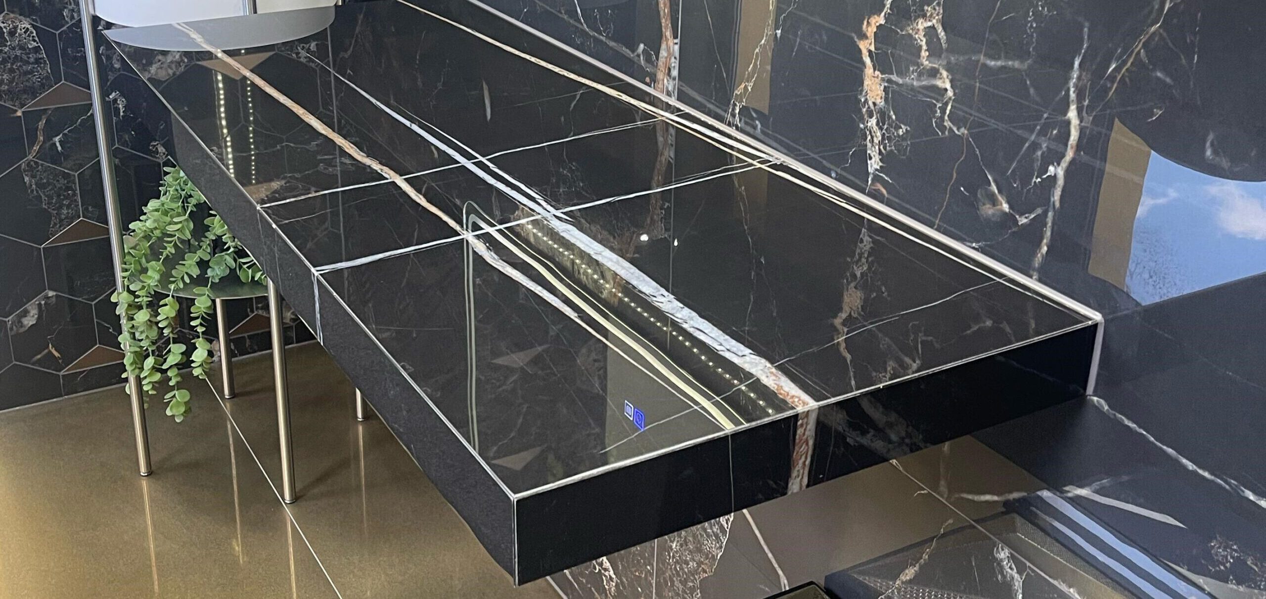 Maßgefertigte Waschtischplatte in Marmoroptik mit goldenen Marmoreierungen auf dunkler Fliese – exklusiv gefertigt vom Madak Meisterbetrieb in Wetzlar.