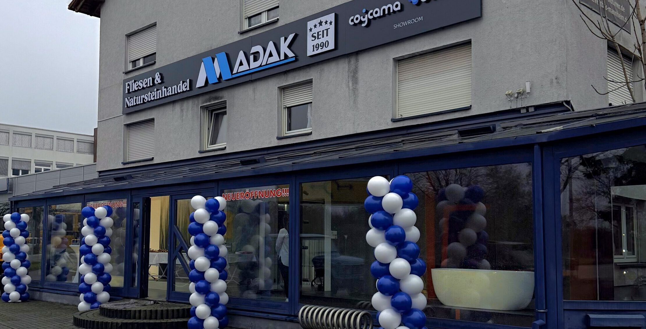 Eingangsbereich von Madak Mannheim zur Jubiläumsfeier mit dekorierten Ballons am Geschäftseingang.
