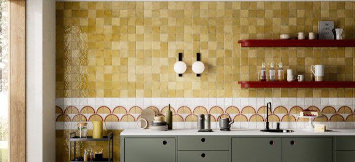 Küchenspiegel mit quadratischen und unterschiedlichen Vintage-Kleinformatfliesen in Dunkel-, Beige- und Goldtönen sowie dekorativen Mustern in Rot, Beige und Weiß.