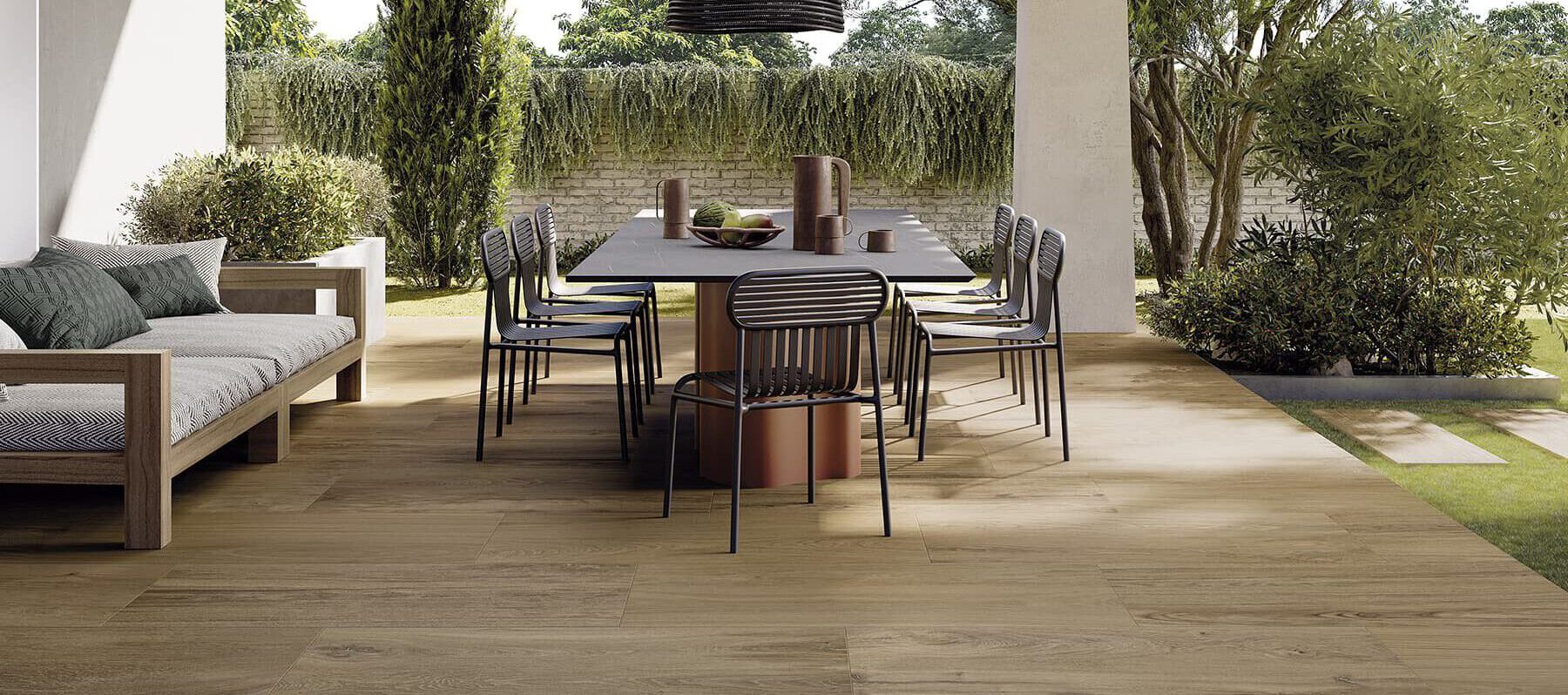 Überdachte Terrasse mit Essbereich und Sofa, großformatige Holzoptik-Dielenfliesen – wetterfest, trittsicher und funktional.