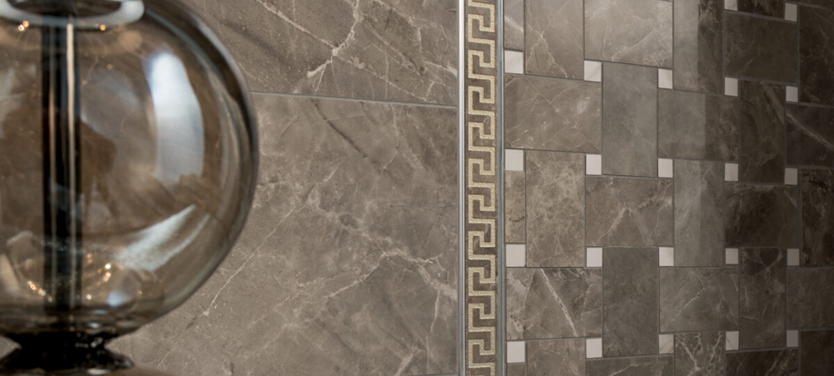 Exklusive Versace-Kleinformatfliesen und Mosaike: Greek Marble Bordüre in Gold/Grau 10 × 58 cm, Mosaiknetz in Grau-Weiß und Natursteinoptik mit weißen Marmoreinsätzen.